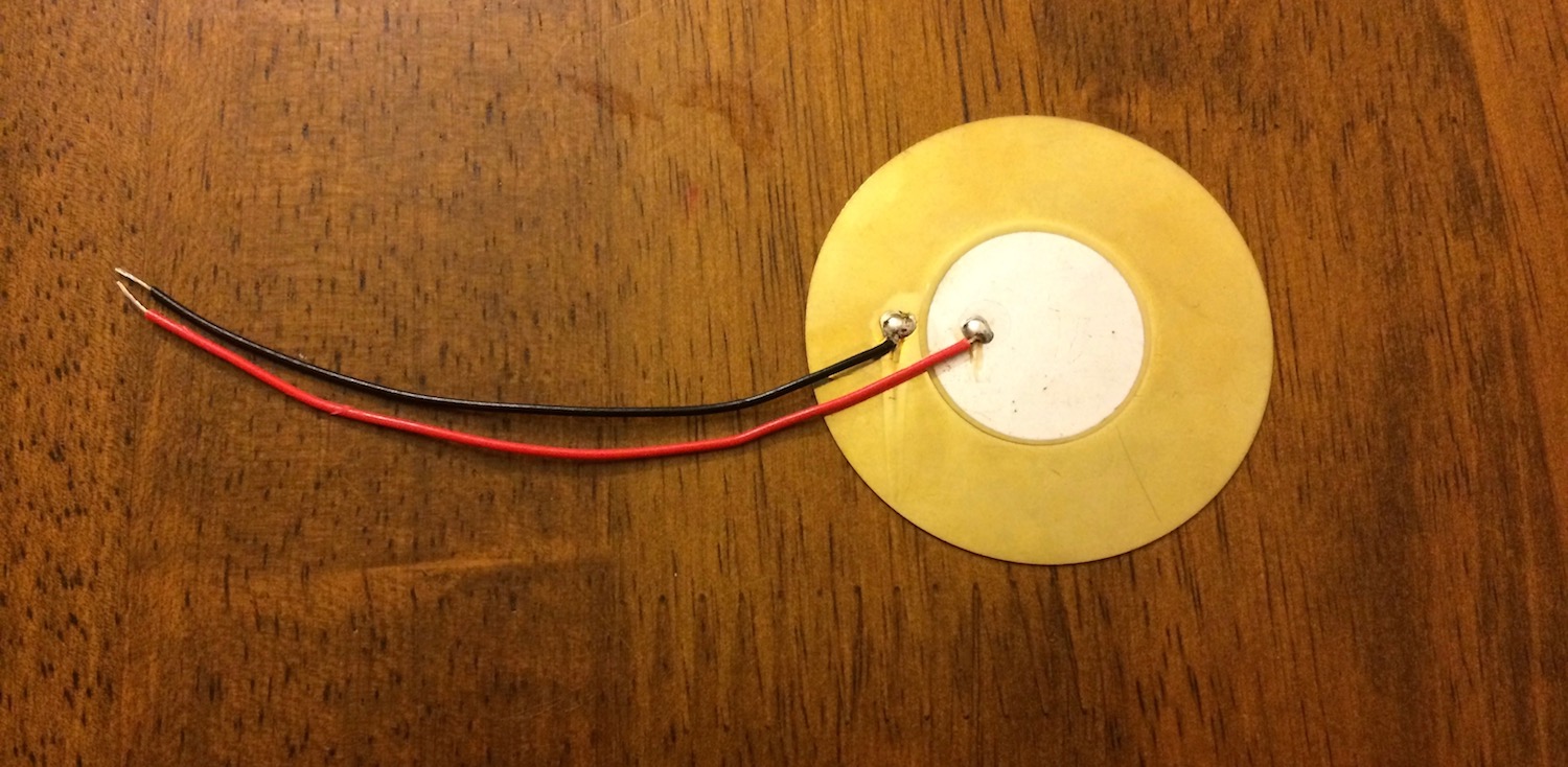 A disk-shaped piezoelectric sensor.
